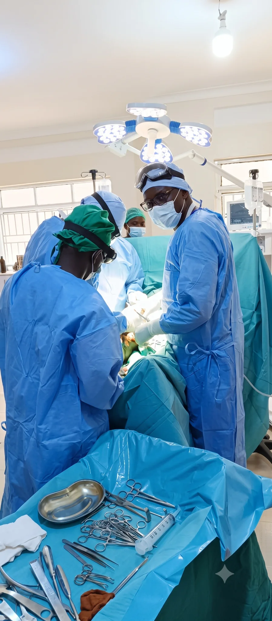 Dr. Raymond Joseph Malinga working with a surgical team in theatre