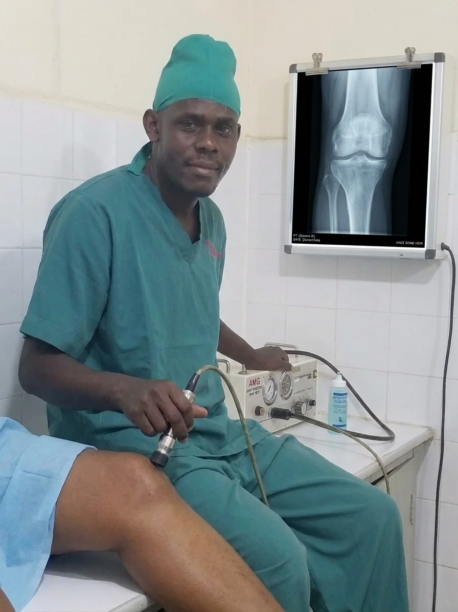 Dr. Raymond Joseph Malinga performing a clinical examination of a patient's knee